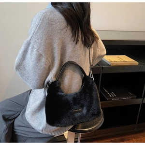Vue latérale d'une femme portant un sac bandoulière en peluche noir avec anse en cuir