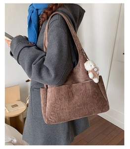 Détail du sac fourre-tout en velours côtelé marron avec broderie et bijou ours