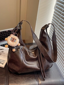 Dunkelbraune Vintage-Schultertasche aus Kunstleder mit plüschigem Löwen-Anhänger