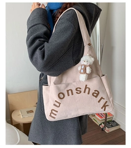 Détail du sac cabas en velours beige avec broderie et pendentif ours en peluche