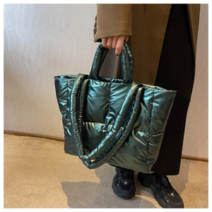 Detailopname van de gewatteerde metallic structuur van de bosgroene grote shopper tas