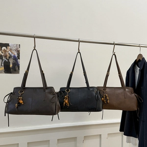Retro shoulder bags in three colors hanging on a rack with beaded pendant details