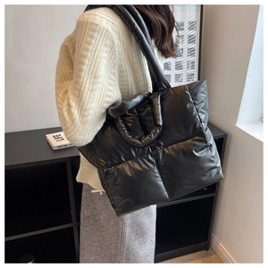 Detail van de zwarte gewatteerde shopper met gevoerde schouderband bij een model