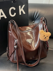 Retro brown oiled leather shoulder bag with silver triangle hardware and plush bear charm