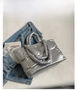 Detail van zilveren gewatteerde shopper met gevoerde handvatten voor de wintermode