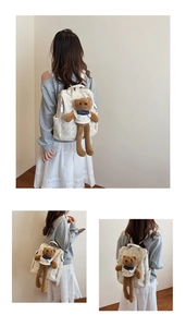 Rear view of a white backpack with cute bear print and a large plush teddy bear charm