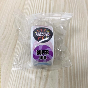 Close-up of a roll of round reward stickers with Awesome and Super Job text designs