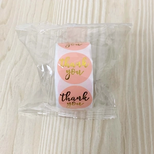 Macro view of assorted pink Thank You roll stickers in transparent packaging