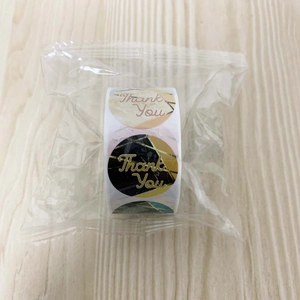 Close-up of thank you sticker roll with marble designs and gold foil script