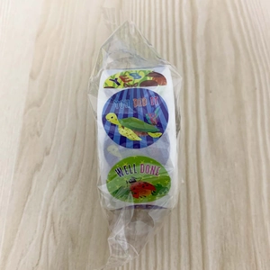 Close-up of children reward stickers roll with cartoon animals and motivational phrases