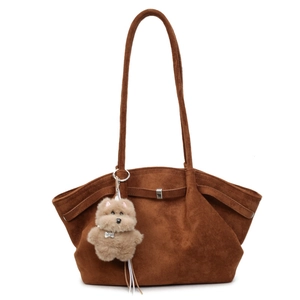 Brown suede tote bag with decorative straps and a plush dog charm for autumn style