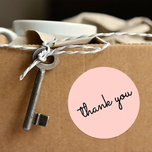 Pink round thank you seal stickers for gift packaging on kraft box with vintage key