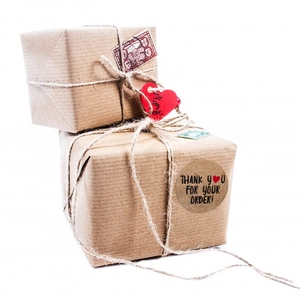 Brown kraft paper thank you stickers with red hearts on a gift box package
