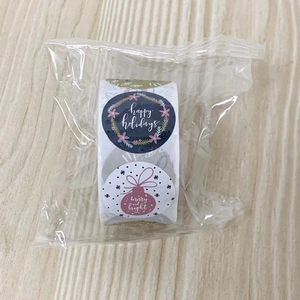 Detail of Christmas roll stickers in plastic wrap featuring festive holiday greetings