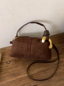 Brown suede pillow bag with unique gold metal buckles and adjustable strap