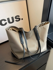 Grand sac fourre-tout en nylon kaki avec anses noires sur surface en bois