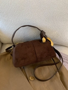 Brown suede minimalist pillow bag with vintage gold hardware and crossbody strap