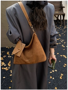 Brown suede Hobo bag with a small envelope charm shown carried over the shoulder