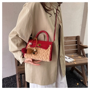 Detail of red leather and beige plush Kelly bag with heart texture and gold lock