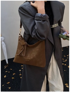 Detail of vintage brown leather hobo bag with gold hardware and mini envelope pouch