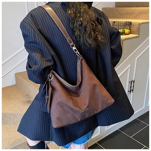 Detail of vintage brown suede tote bag with adjustable wide strap and detachable small pouch
