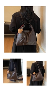Detail of dark brown PU leather tote bag with zip pocket and plush bear pendant detail