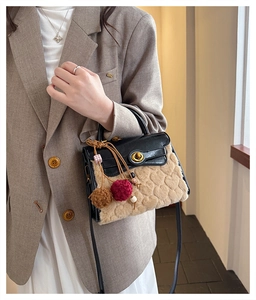 Detail of plush heart-embossed bag with faux fur texture and glossy leather flap