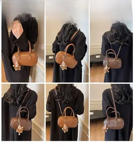 Vues détaillées du sac Boston vintage avec breloque en peluche et texture cuir
