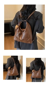 Detail showing vintage brown tote bag texture with side zipper and plush bear charm