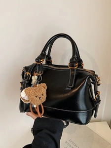Bolso Boston retro negro brillante con costuras blancas y colgante de oso
