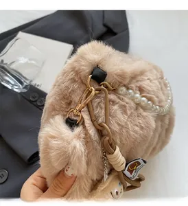 Vue détaillée du sac en fausse fourrure beige avec chaîne en perles et fermoir doré