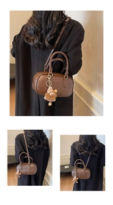 Vue détaillée du sac Boston rétro marron avec gaufrage et pendentif ours