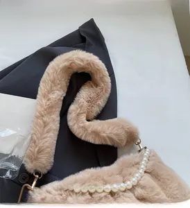 Gros plan du sac en peluche marron clair avec chaîne en perles et texture douce
