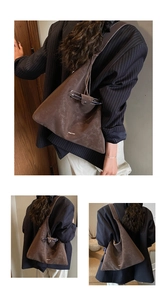 Detailed view of deep brown large tote bag with chic textured finish and gold logo
