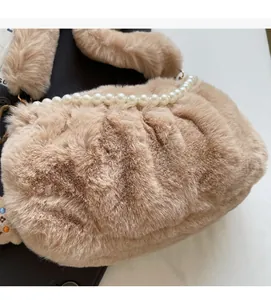 Détail d'un sac à main en fausse fourrure kaki avec une bandoulière élégante en perles blanches