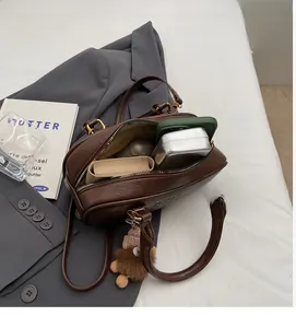 Détails de l'intérieur du sac bandoulière marron foncé avec espace pour téléphone mobile