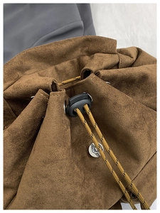 Gros plan détaillé d'un sac à dos en daim marron avec cordon de serrage et bouton métallique