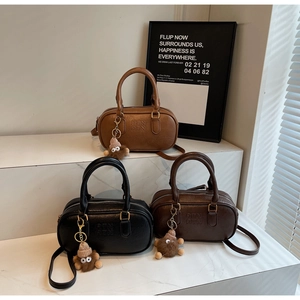 Trois sacs Boston en noir, marron et café avec des charms en peluche pour sacs à main