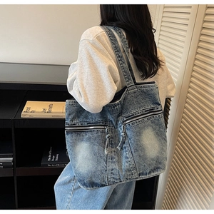 Détail d'un grand sac cabas en denim délavé avec fermetures éclair pour le quotidien