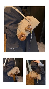 Close-up of khaki retro bag with cute donut and heart charms on a textured PU leather surface
