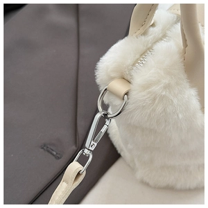 Detail view of plush beige faux fur texture with apricot leather strap and silver metal buckle