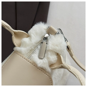 Detail of silver zipper and plush faux fur texture on the stylish beige leather handbag