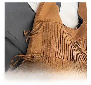 Detail of a brown suede shoulder bag featuring long fringe and premium retro bohemian texture
