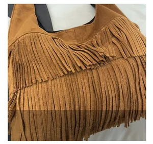Close-up of brown suede tote bag featuring multi-layered long fringe tassel details