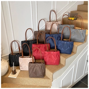 Detail view of colorful pleated nylon tote bags with golden buckles on stairs