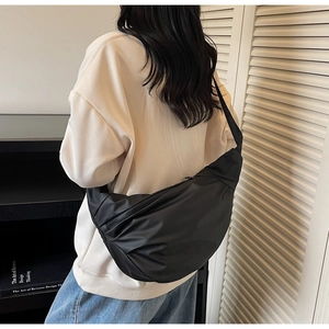 Détail d'un sac bandoulière demi-lune noir en nylon avec large bandoulière réglable