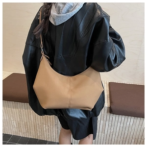 Sac hobo en cuir marron porté par un mannequin avec une tenue élégante et sobre