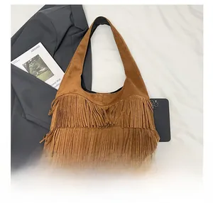 Close-up of brown suede hobo bag featuring decorative double-layered long tassels