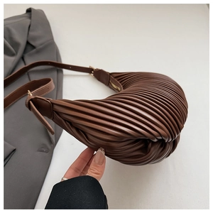 Close-up of dark brown pleated crescent bag with adjustable strap and metal buckle