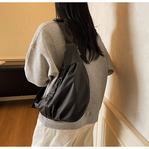 Vue détaillée du sac bandoulière en nylon noir minimaliste avec tissu imperméable
